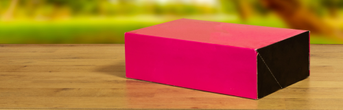 Różowo-czarne pudełko leżące na biurku